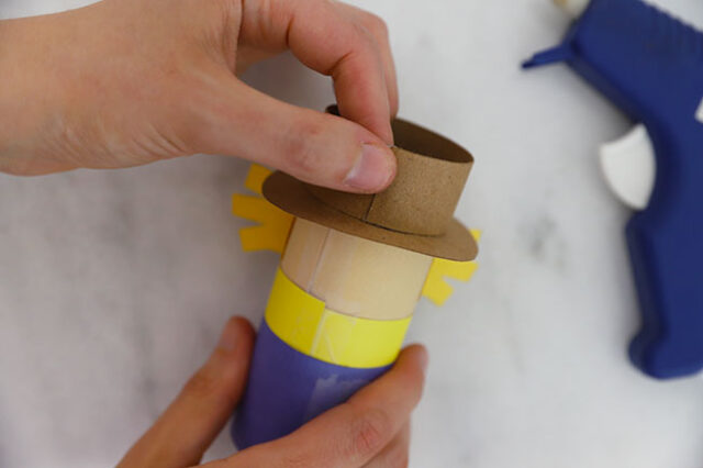 Hot gluing hat paper onto tube