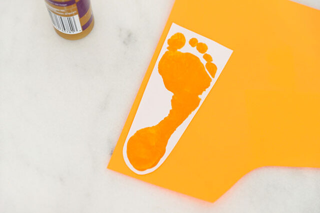 Gluing footprints onto orange paper