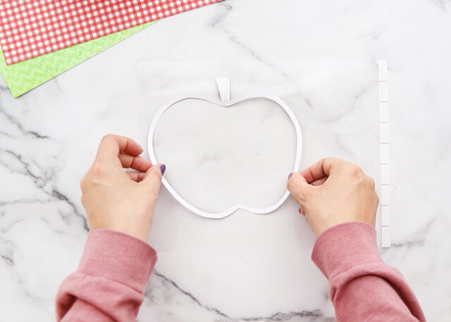 Placing apple onto sticky laminating sheet