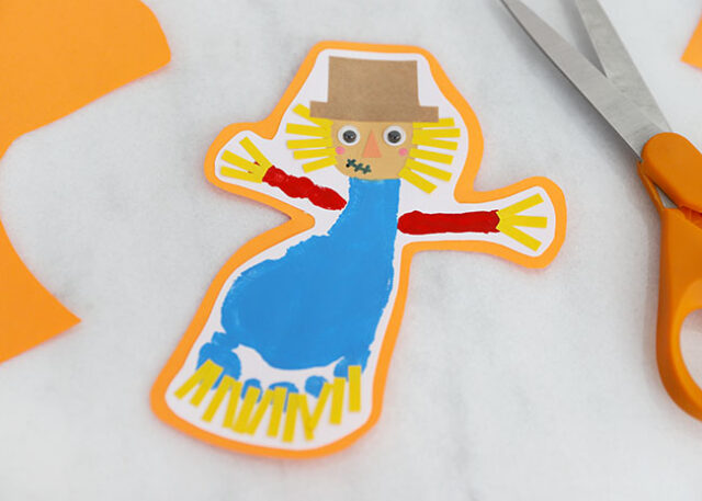 Glue scarecrow onto colored paper