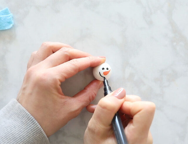 Add Face to Snowman with Paint Pens