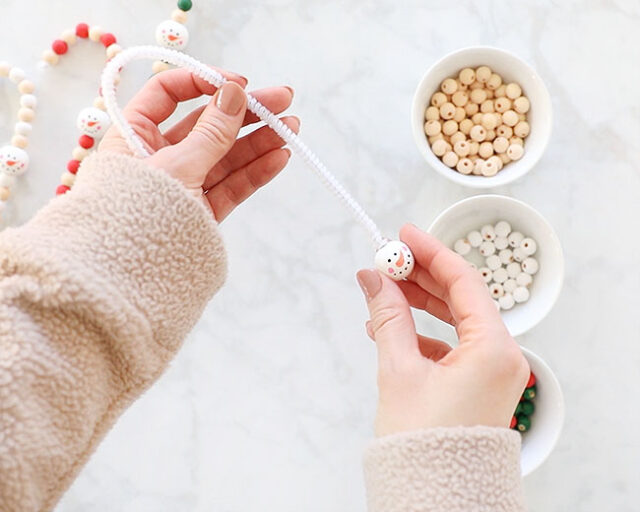 Slide snowman bead onto pipe cleaner