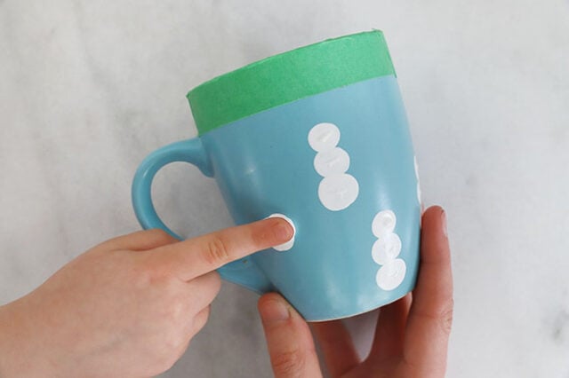 Stamping finger onto mug for snowman