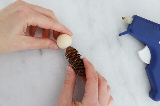 Gluing bead to pine cone