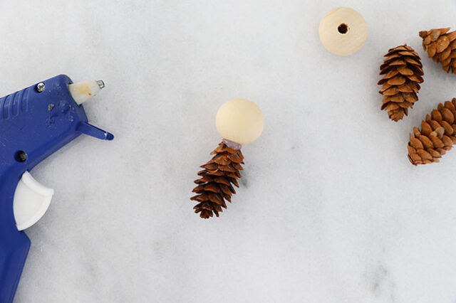 Glueing bead onto pine cone body