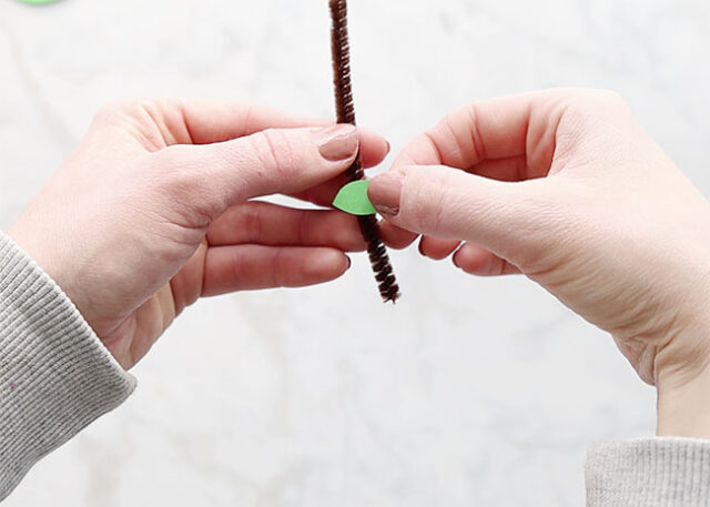 Gluing leaf onto pipe cleaner